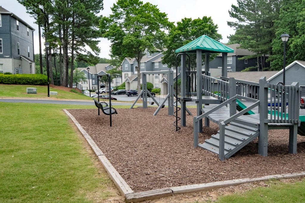 A playground with a green roof and a slide.