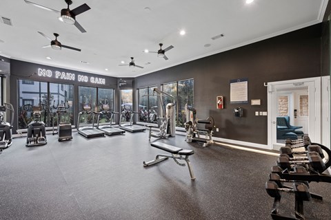 A gym with a variety of equipment including treadmills, weights, and exercise machines. at The Ambrose, Houston, Texas