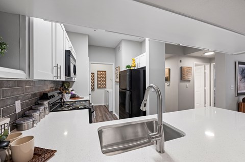 A modern kitchen with a white countertop and stainless steel appliances. at The Ambrose, Texas, 77040