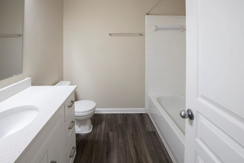 A white bathroom with a toilet, sink, and bathtub.