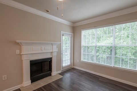 A room with a fireplace and a window with blinds.