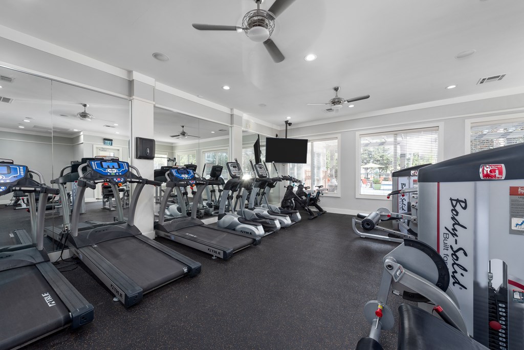 A gym with treadmills and exercise equipment. A gym with treadmills and exercise equipment at The Fenwick Apartments, Humble