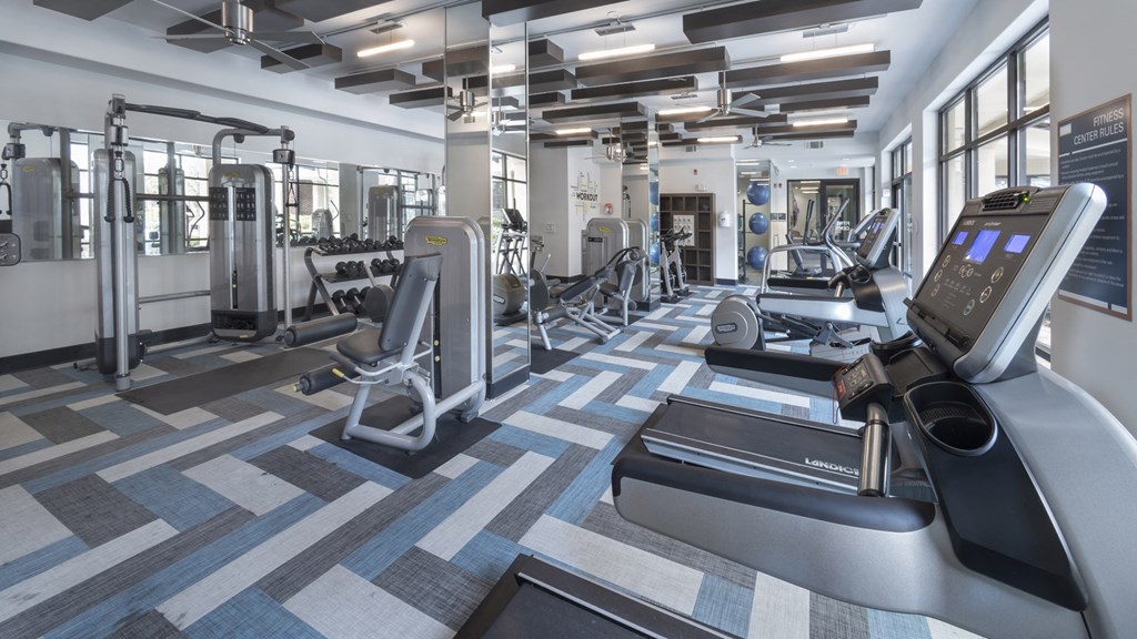a gym with treadmills and other exercise equipment in a building with windows at The Hendrix, Atlanta