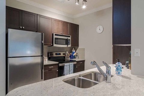 A kitchen with a stainless steel refrigerator and a microwave oven.