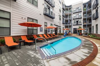 A small pool surrounded by orange chairs and umbrellas. at The Tennessee Brewery, Memphis, Tennessee