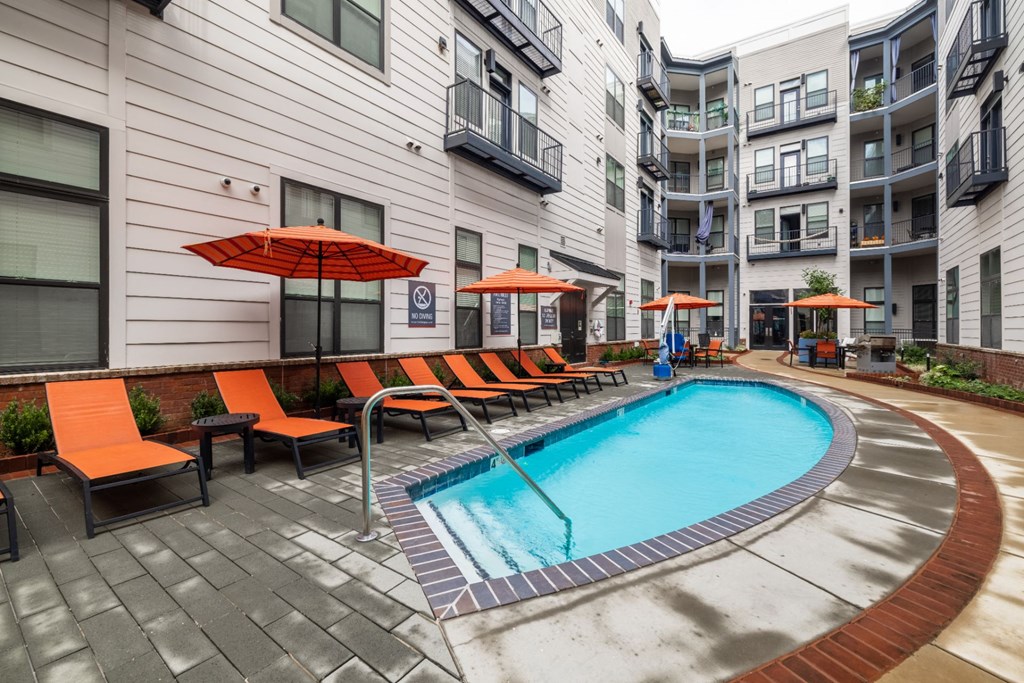 A small pool surrounded by orange chairs and umbrellas. A small pool surrounded by orange chairs and umbrellas. at The Tennessee Brewery, Memphis, 38103