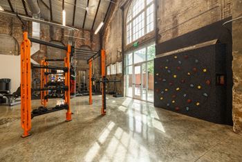 A gym with orange equipment and a climbing wall. at The Tennessee Brewery, Memphis, 38103