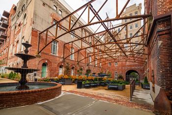 A courtyard with a fountain and a brick building. at The Tennessee Brewery, Memphis, TN