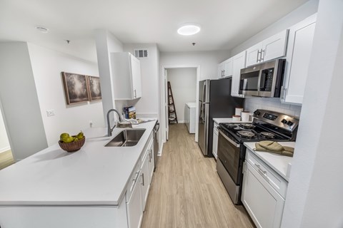 A modern kitchen with white cabinets and stainless steel appliances.