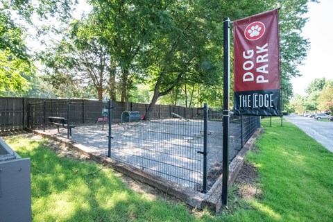 A sign for Dog Park The Edge is displayed on a fence.