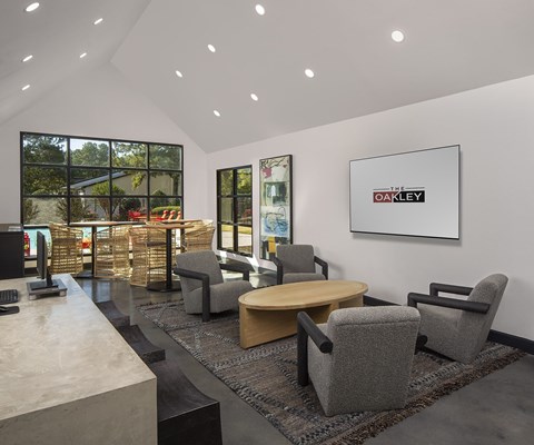 A modern office space with a large window, a desk, and chairs.
