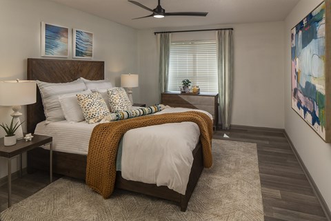 A bedroom with a large bed and a ceiling fan.