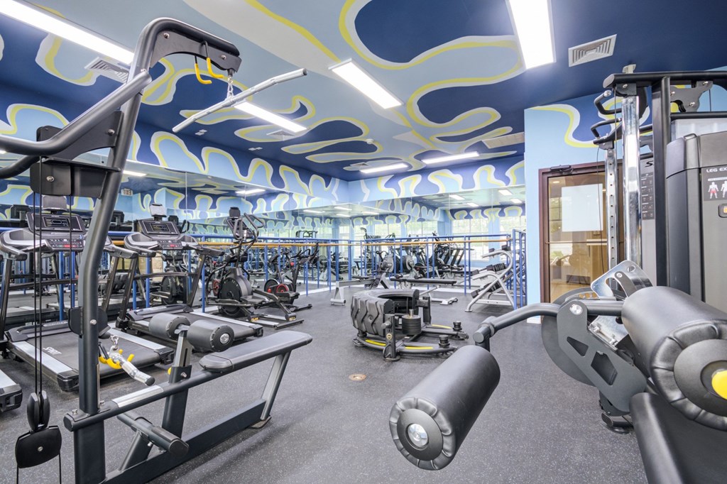 A gym with a variety of equipment including a leg press machine.