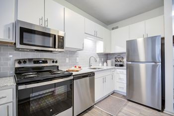A kitchen with a stove, oven, microwave, and refrigerator.