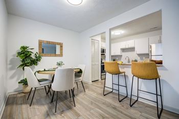 A kitchen with a dining table and chairs.