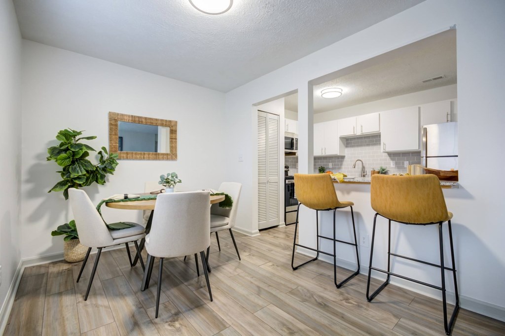 A kitchen with a dining table and chairs.