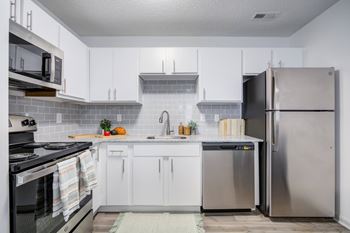 A kitchen with white cabinets and a black stove top oven.