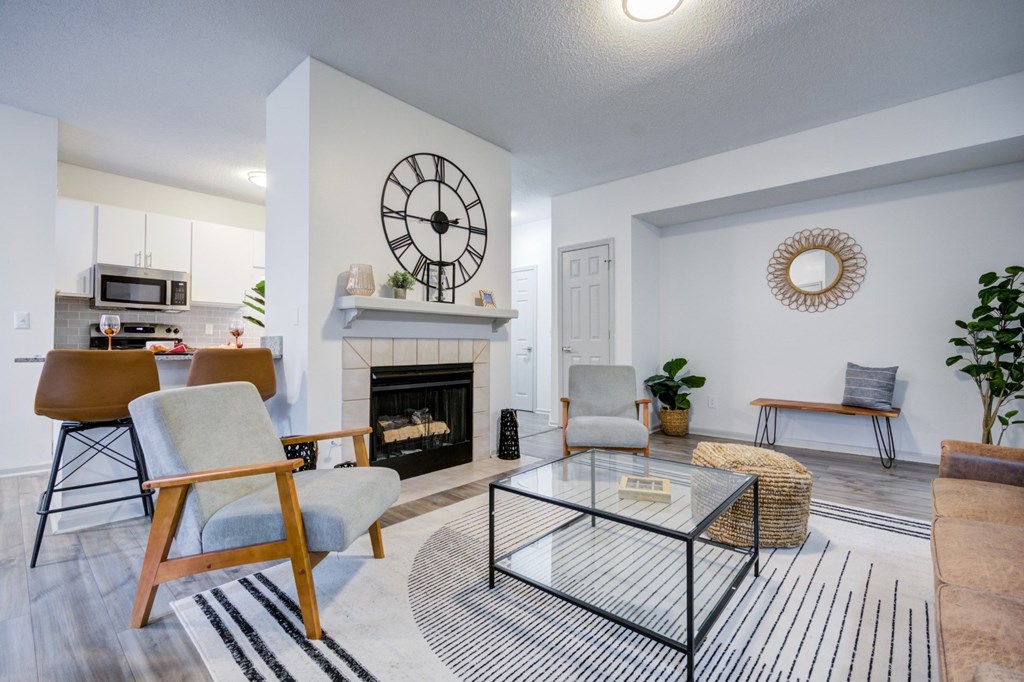 A living room with a fireplace and a large clock on the wall.
