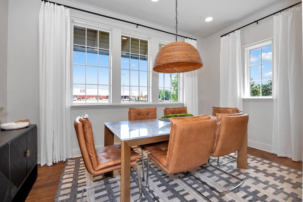 a dining room with a table and chairs and a large window