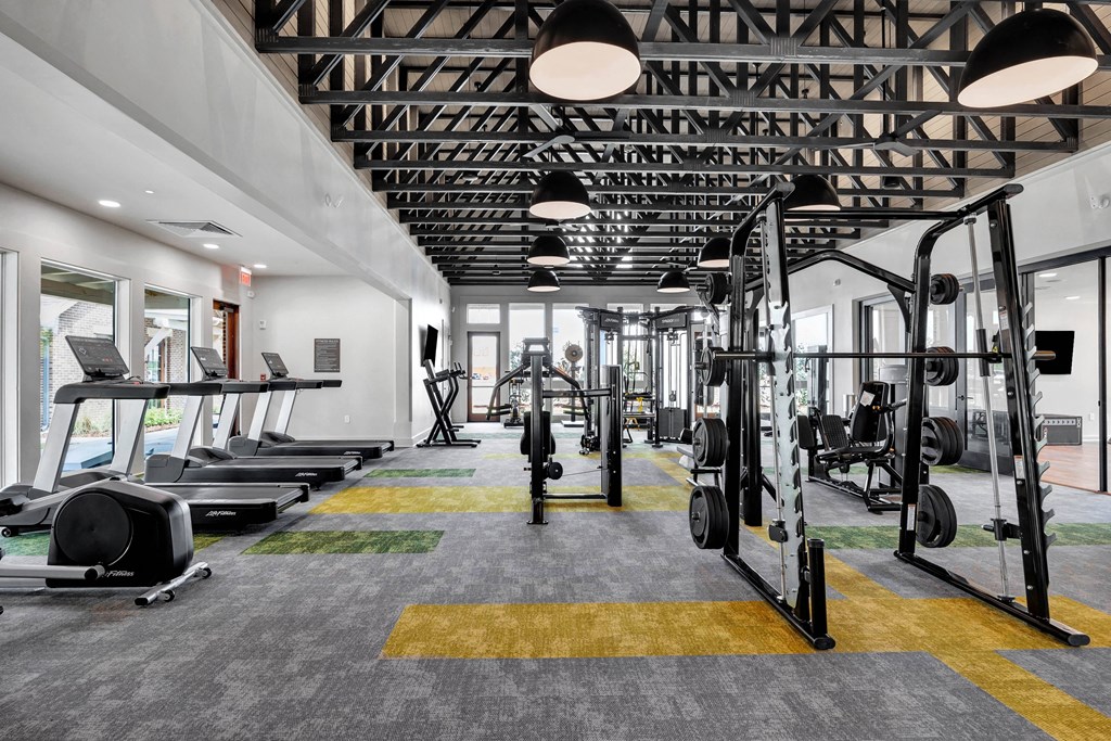 a gym with treadmills and weights in a building with glass doors