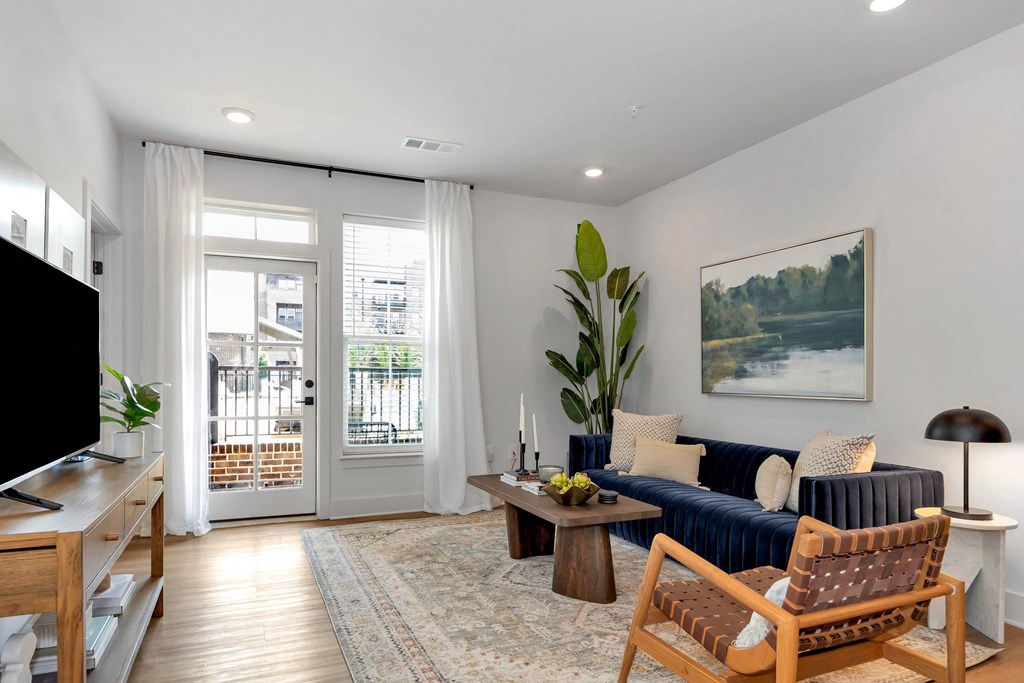 a living room with a blue couch and chairs and a tv