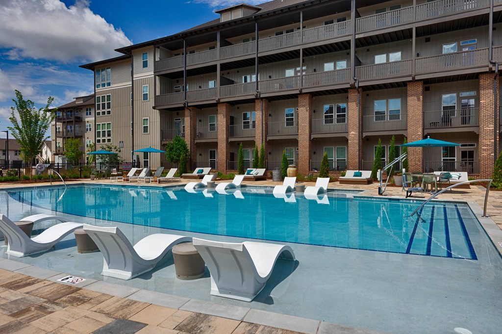 a large swimming pool in front of an apartment building