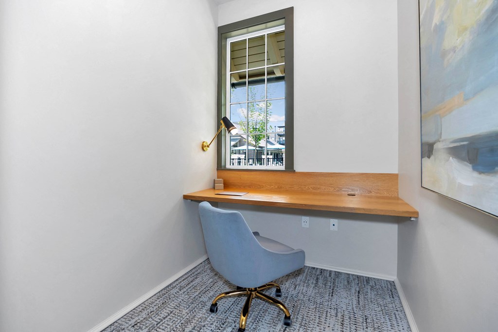 a desk with a chair in a room with a window