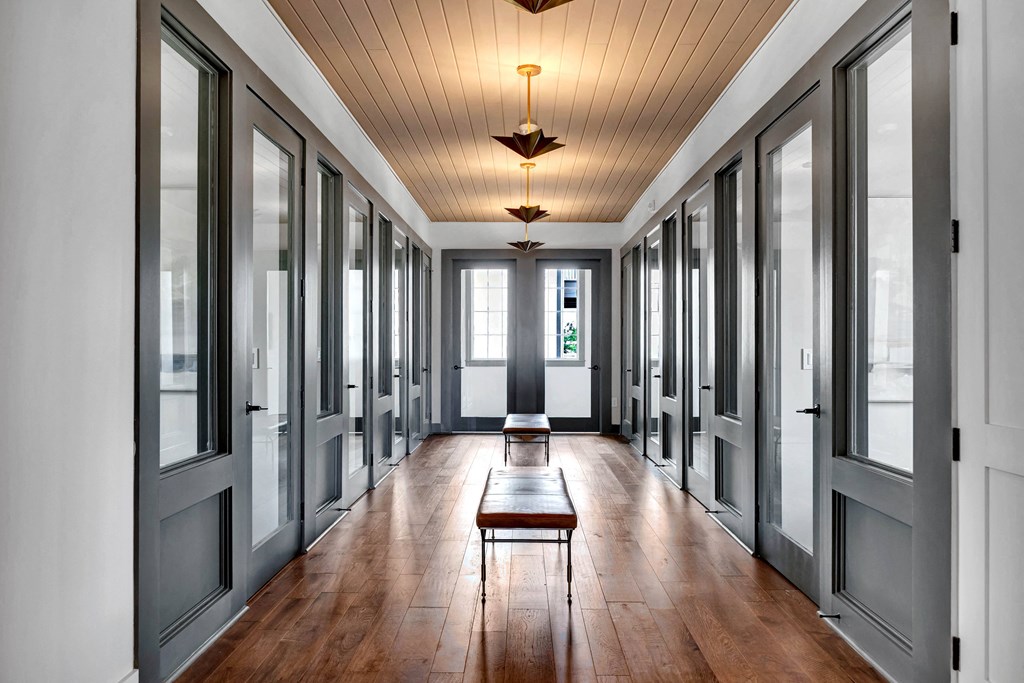 a long hallway with many windows and a table