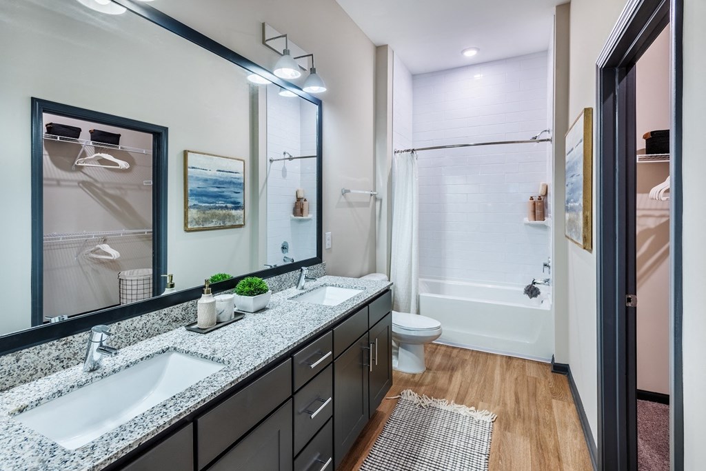 a bathroom with a large mirror and two sinks at The Livano Tryon, Charlotte, 28213