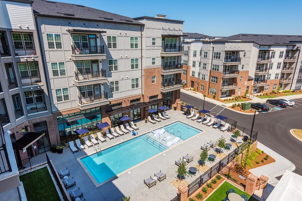 an aerial view of a resort style pool with lounge chairs and umbrellas in front of at The Livano Tryon, North Carolina, 28213