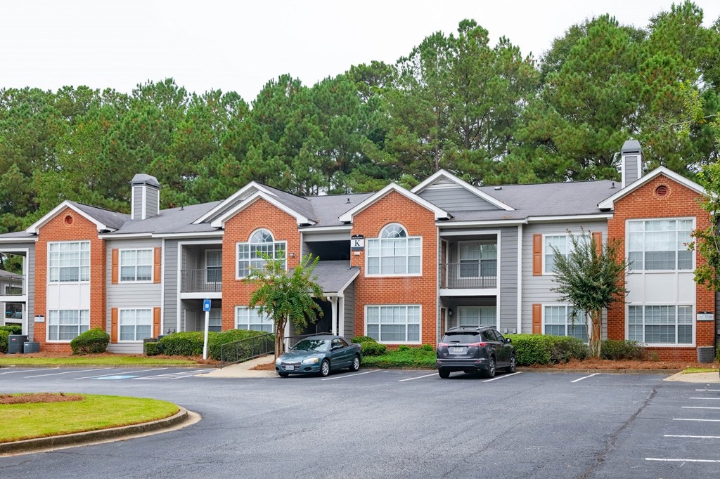 an apartment building with cars parked in a parking lot at Twenty35 at Timothy Woods, Athens, Georgia