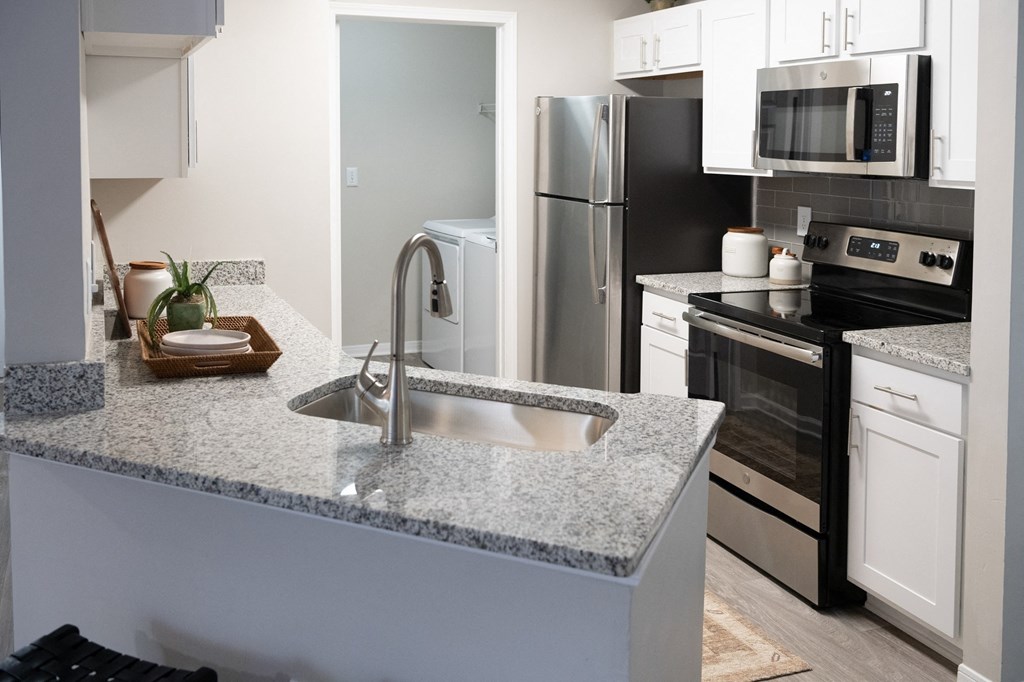 an open kitchen with granite counter top and stainless steel appliances at Twenty35 at Timothy Woods, Athens, GA