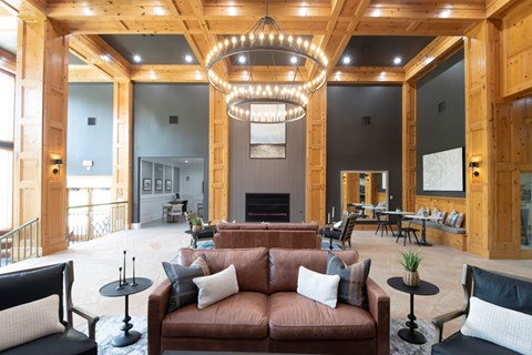 A large, open-concept living room with a fireplace and a chandelier.