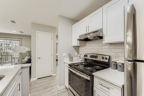A kitchen with a stove top oven and a refrigerator.
