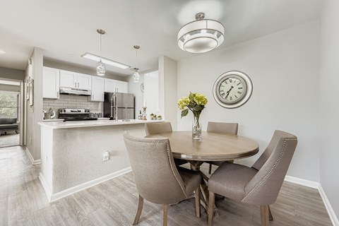 Dining area with round table and open kitchen view at Wood Terrace Apartments, Doraville, GA