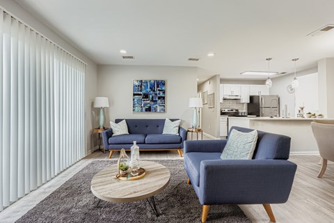 A living room with a blue sofa and a grey rug.