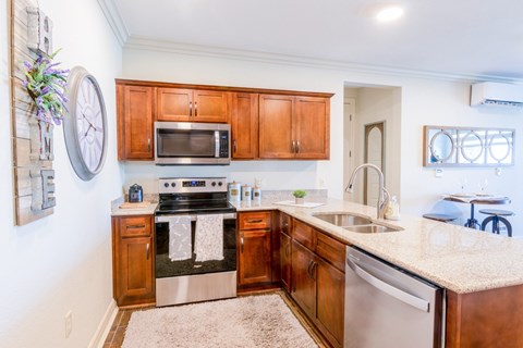 A kitchen with wooden cabinets and a stove top oven.at Carson Street Towers, Overland Park, 66223