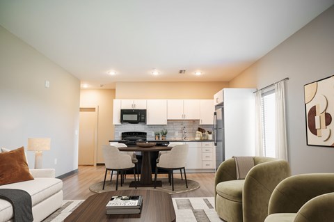 A modern living room with a dining area and kitchen in the background.