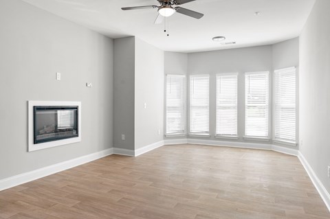 A spacious room with a fireplace and a ceiling fan. at Manchester at Mansell, Roswell, GA 30076 