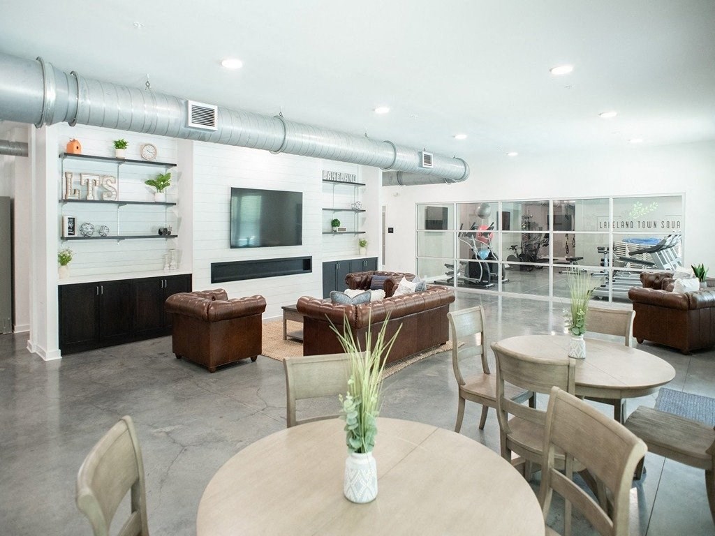 a living room with couches tables and chairs and a tv