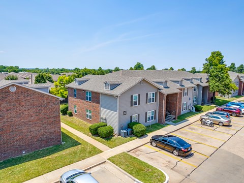 A car is parked in a parking lot in front of a building.