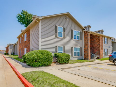 A row of houses with a blue car parked in front of the last one.