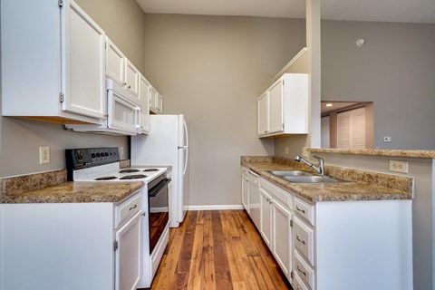 A kitchen with white cabinets and a granite countertop.