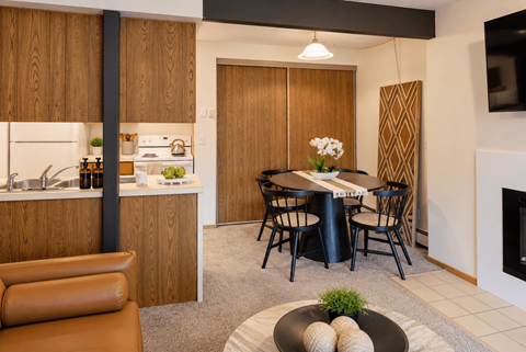 A modern kitchen with a dining table set for two.