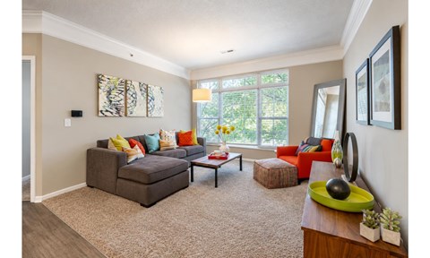A living room with a grey couch and a green side table.