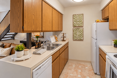 A kitchen with wooden cabinets and a white refrigerator.
