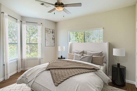 A bedroom with a large bed and a ceiling fan.