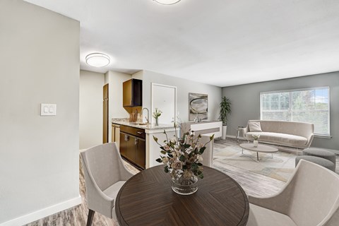 A modern living room with a dining table and chairs.