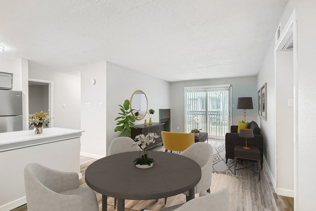 A modern dining room with a round table and grey chairs.