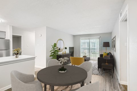 A modern dining room with a round table and grey chairs.